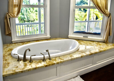 Luxury soaking tub at Saint Patrick Palace with granite surround and garden views in Davie, Florida