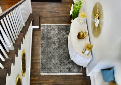 Elegant foyer at Saint Patrick Palace with wood floors, gold mirrors, and stylish modern décor in Davie, Florida
