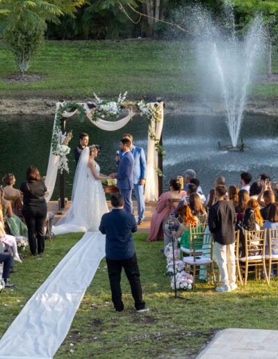 Elegant lakeside wedding with a floral arch and fountain backdrop at Saint Patrick Palace.