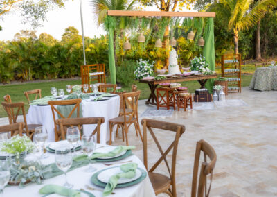 Elegant green & white outdoor wedding with rustic chairs and a lush dessert display.