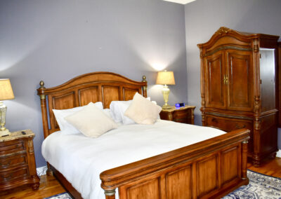 Elegant guest bedroom with wood furnishings and cozy bedding at Saint Patrick Palace