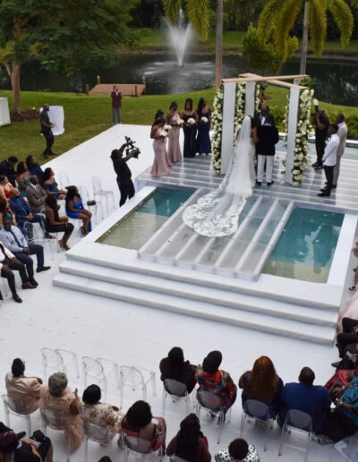 Modern white poolside wedding ceremony with glass platform at Saint Patrick Palace.