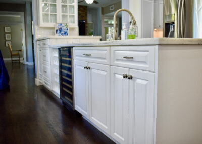 Elegant kitchen with white cabinets, marble counters, and wine cooler at Saint Patrick Palace