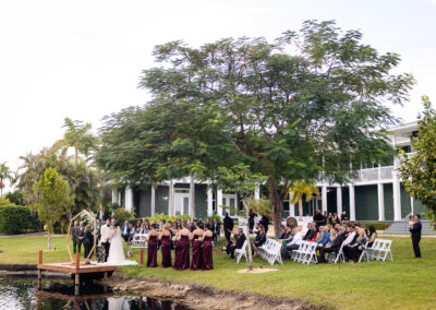 Waterfront wedding ceremony at Saint Patrick Palace with lush greenery and a romantic dock altar.