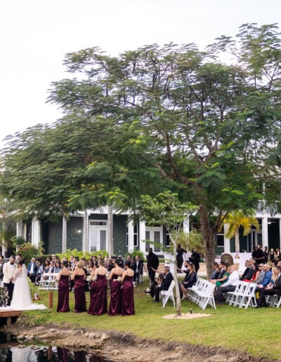 Waterfront wedding ceremony at Saint Patrick Palace with lush greenery and a romantic dock altar.