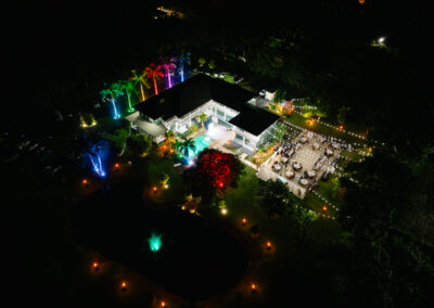 Luxury estate wedding with vibrant lighting, string lights, and outdoor dining under the stars.
