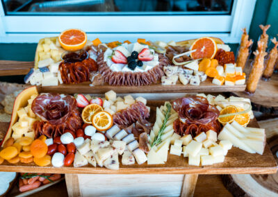 Gourmet charcuterie board with artisan cheese, cured meats, and fresh fruit for weddings & parties.
