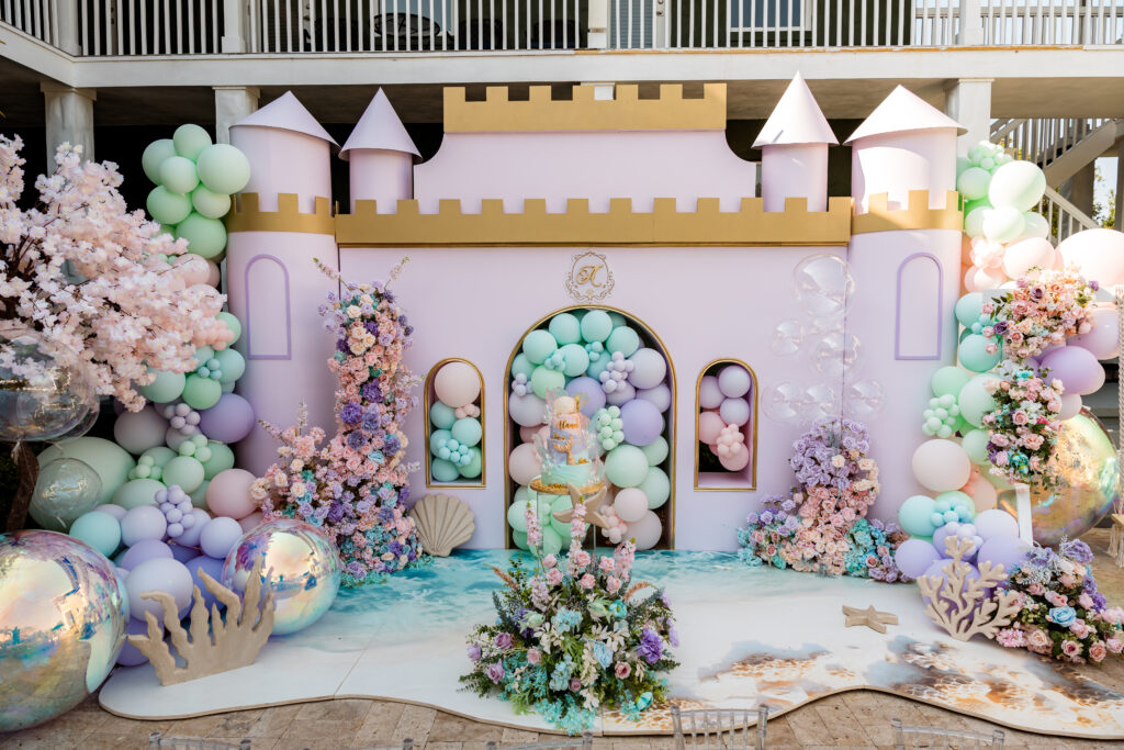 Pastel castle backdrop with balloons and florals for luxury birthday or themed events.
