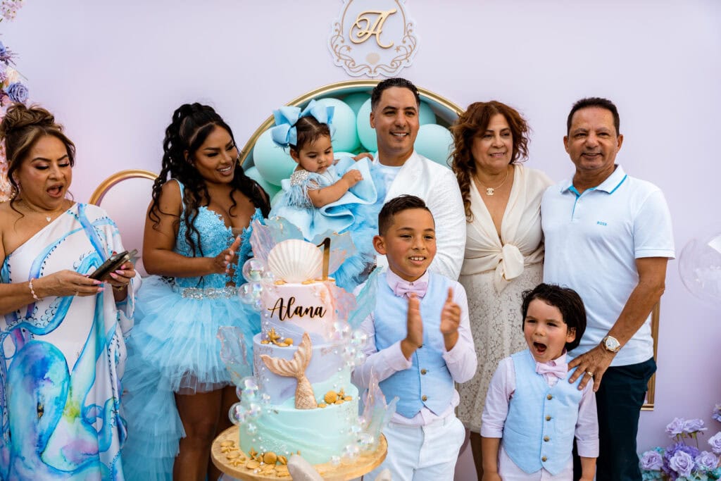 Whimsical mermaid-themed first birthday party with custom cake and matching family outfits.