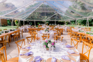Elegant clear tent wedding with lavender accents, wood chairs, and romantic rose centerpieces at Saint Patrick Palace.