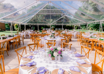 Elegant clear tent wedding with lavender accents, wood chairs, and romantic rose centerpieces at Saint Patrick Palace.