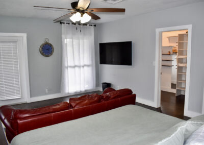 Bedroom with red sofa, TV, and walk-in closet at Saint Patrick Palace Davie