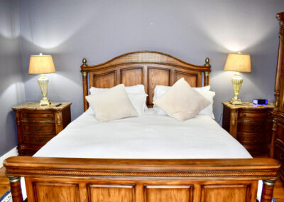 Classic guest bedroom at Saint Patrick Palace with wood bedframe, warm lighting, and cozy décor in Davie, Florida