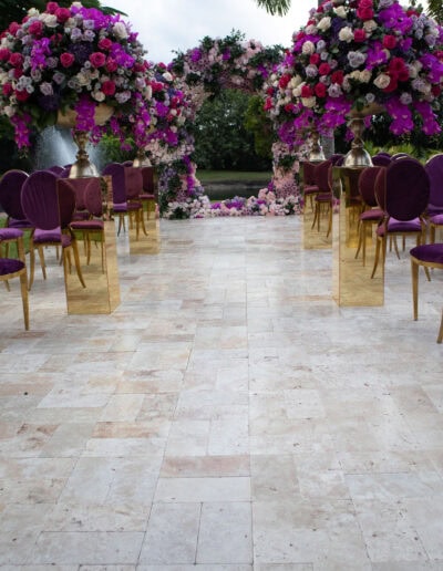 Luxury purple & gold wedding aisle with lush florals at Saint Patrick Palace.