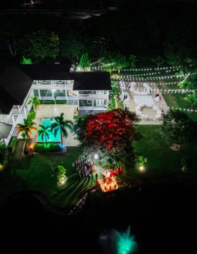 Vibrant nighttime wedding at Saint Patrick Palace with colorful uplighting, string lights, and waterfront elegance.