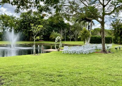 Lakeside wedding ceremony with dock, fountain views, and romantic floral arch at Saint Patrick Palace.
