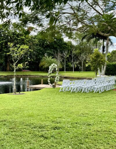 Lakeside wedding ceremony with dock, fountain views, and romantic floral arch at Saint Patrick Palace.