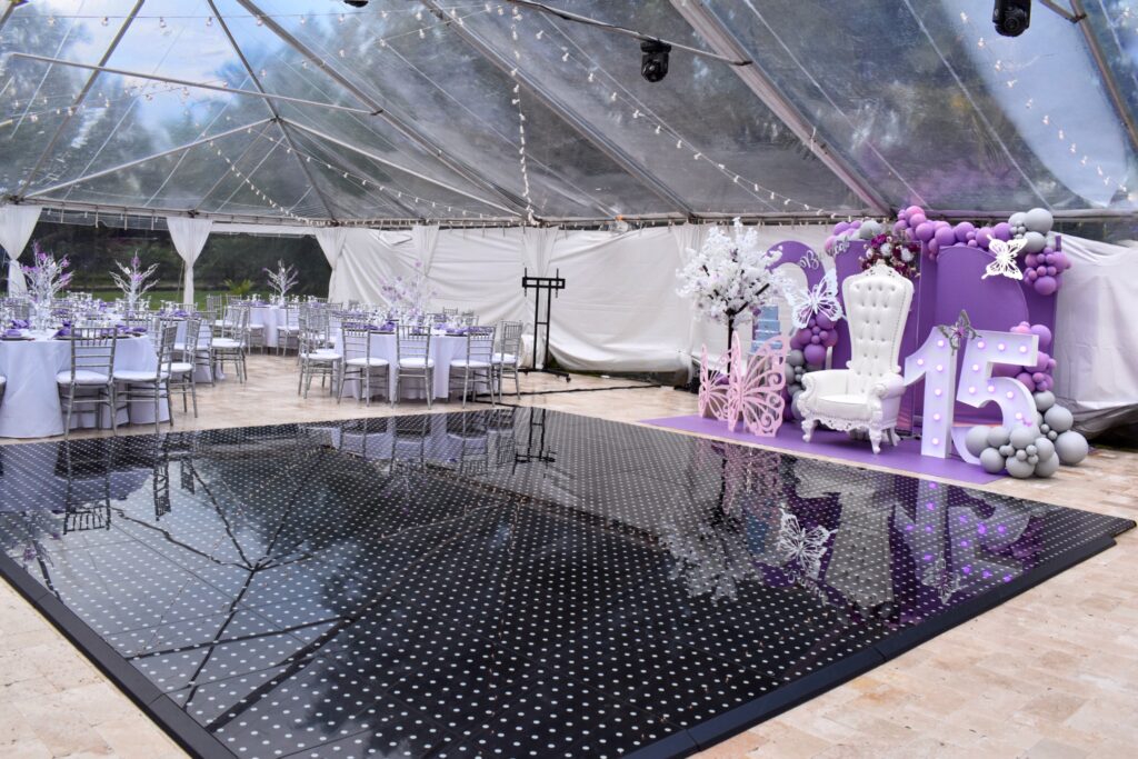 Lavender and silver quinceañera reception with clear-top tent and starlight dance floor at Saint Patrick Palace.