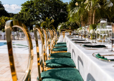 Emerald velvet chairs with gold frames at outdoor reception