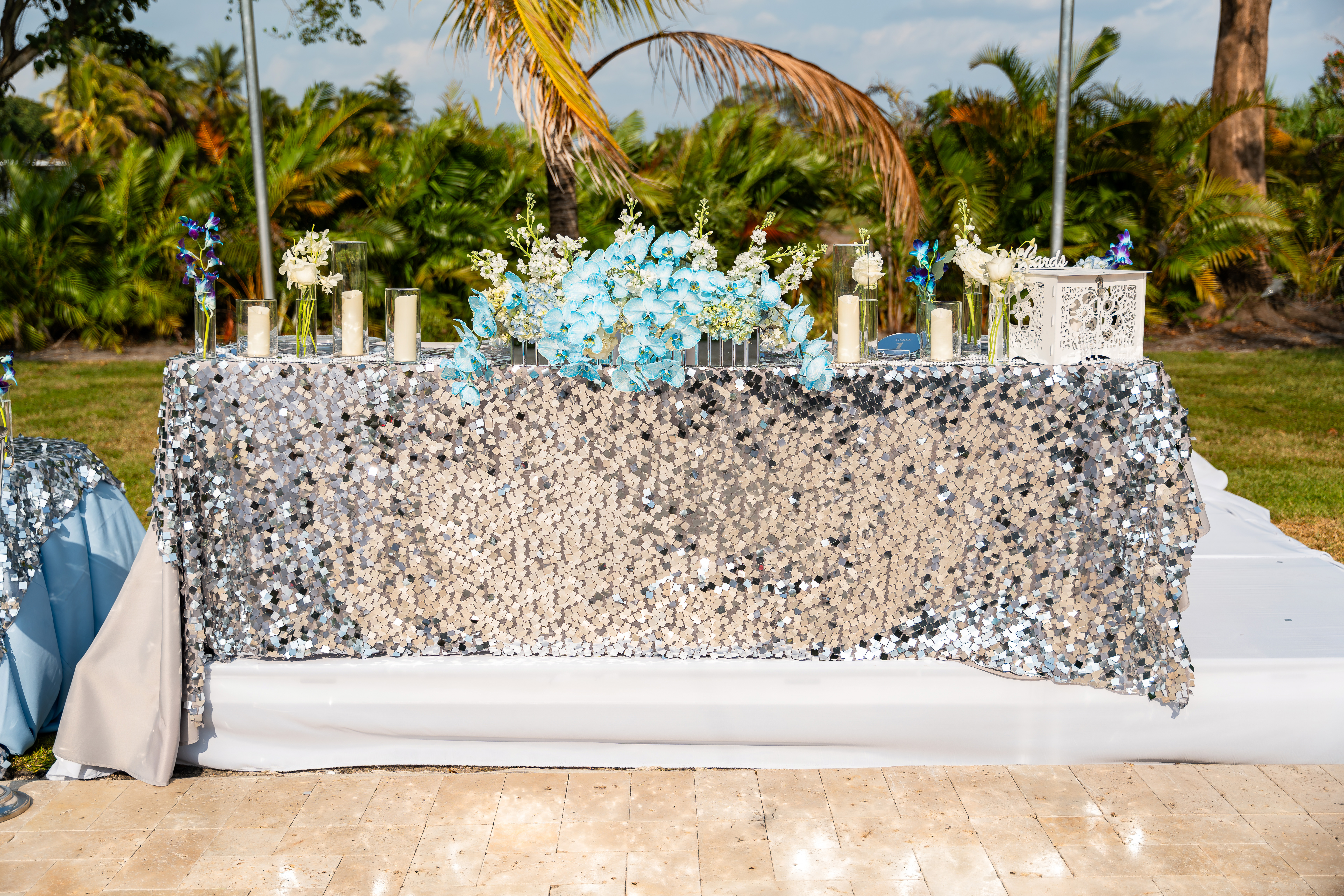 Silver sequin sweetheart table with blue orchids and candles at Saint Patrick Palace reception.