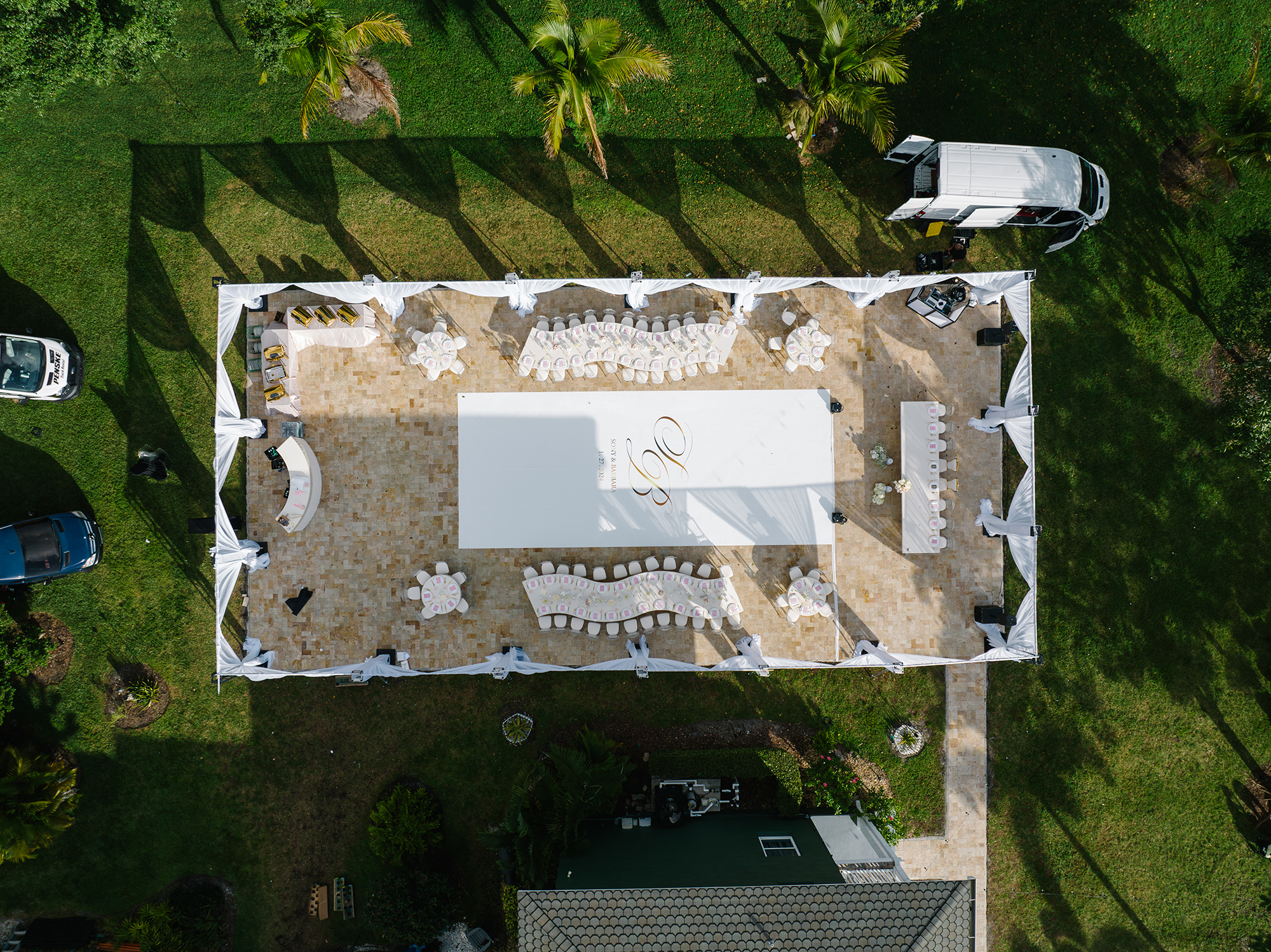 Aerial view of the winter wedding reception tent with curved tables, white dance floor, and draped canopy at Saint Patrick Palace.