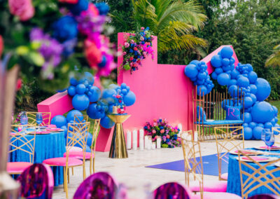 Bold pink & blue balloon backdrop with luxe florals—perfect for modern outdoor weddings & celebrations.