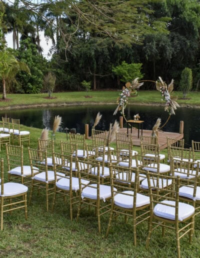 Pondside wedding with pampas arch & gold Chiavari chairs.