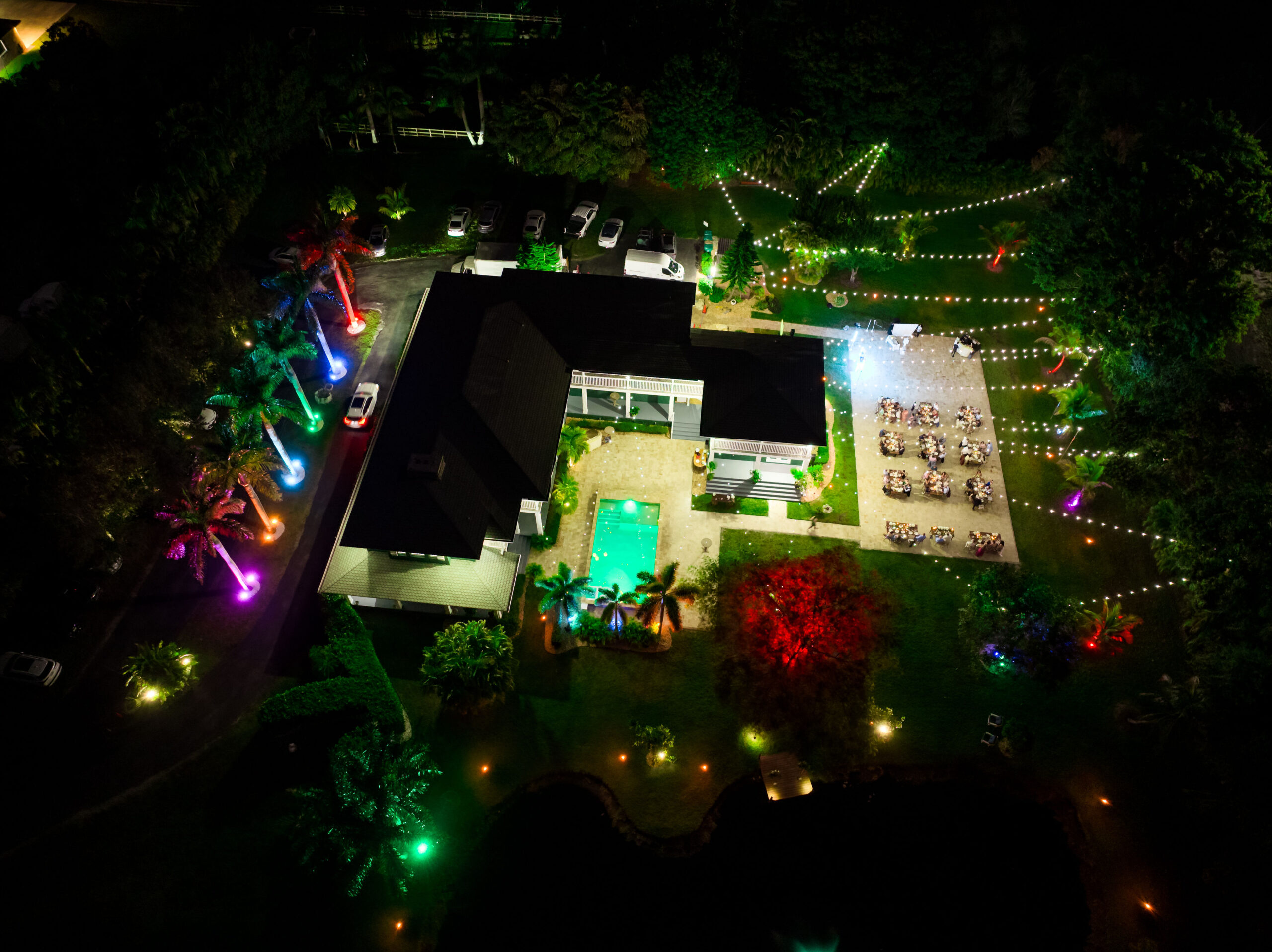 Aerial view of Saint Patrick Palace lit for a quinceañera celebration with string lights and palm uplighting.