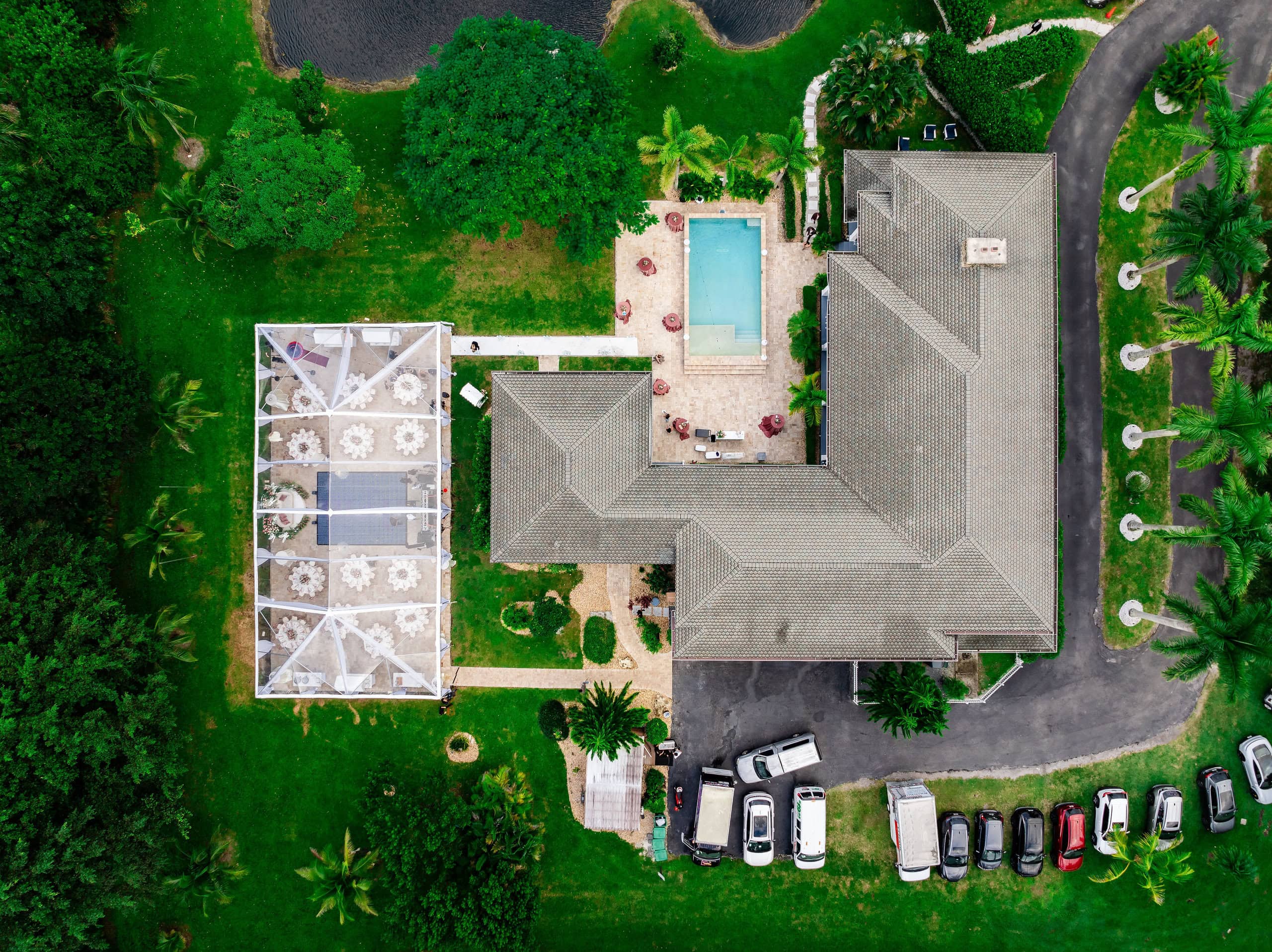 Aerial view of private estate quinceañera venue in South Florida with clear-top tent, pool, and outdoor event spaces