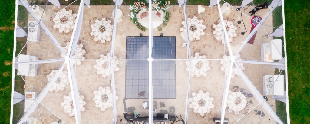 Aerial drone view of a tented wedding reception layout showing table spacing and dance floor placement