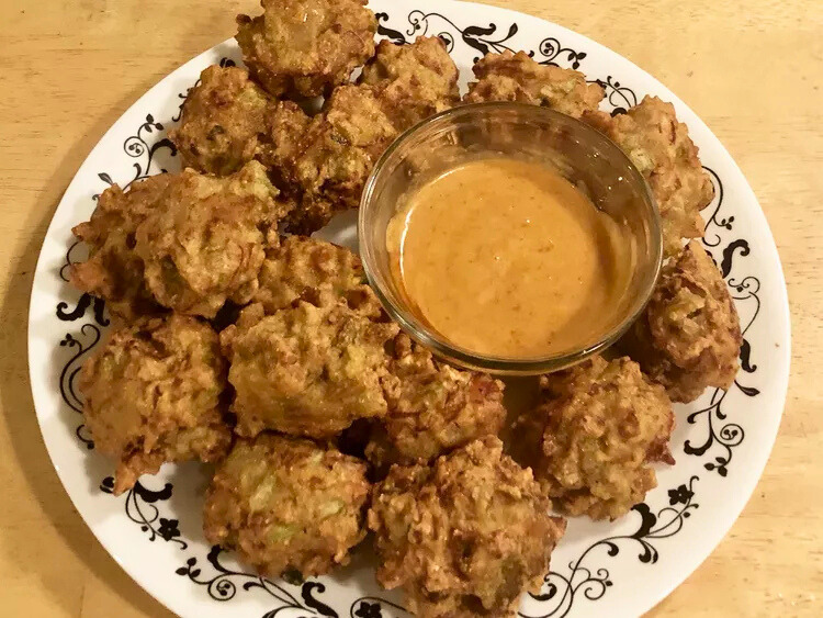 Golden Bahamian conch fritters with dipping sauce, a Caribbean wedding favorite in South Florida.