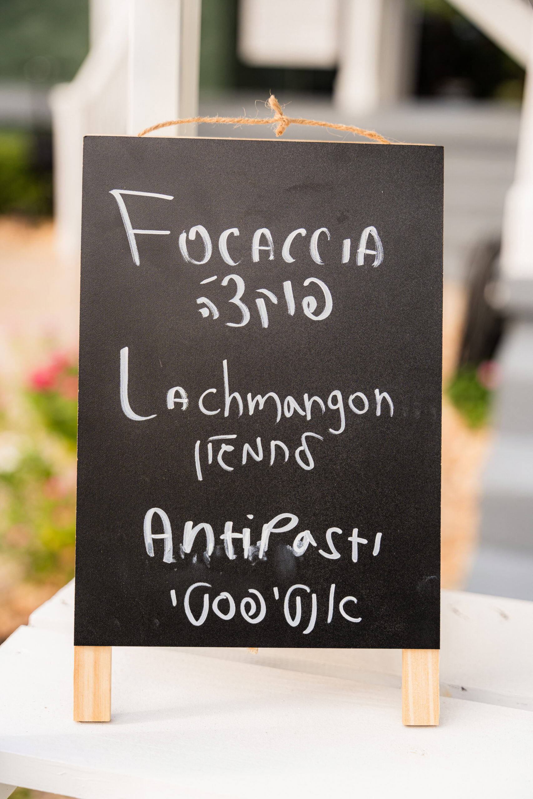 Chalkboard menu with focaccia, lachmangon, and antipasti for Bar/Bat Mitzvah catering inspiration.
