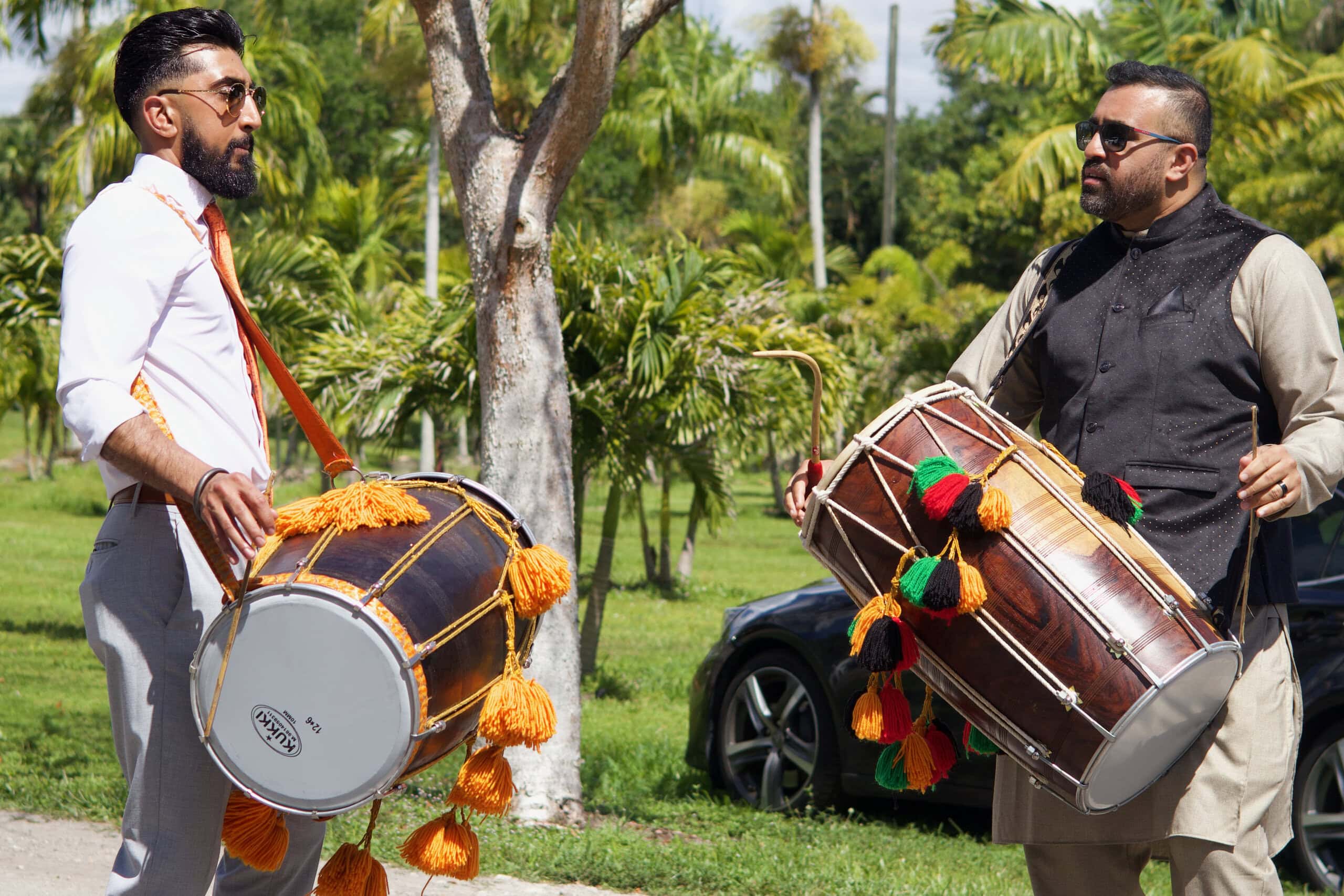 Bespoke event entertainment with two dhol drummers performing at an outdoor South Florida celebration.