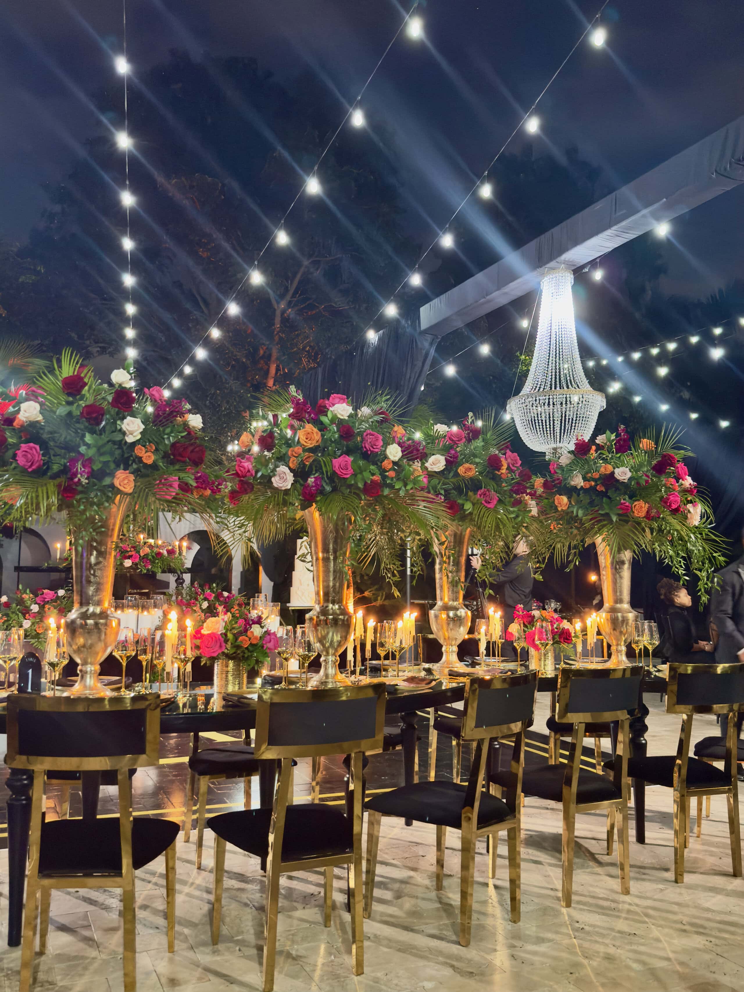 Long table reception with lush florals and candlelight at a modern black-tie garden wedding in South Florida