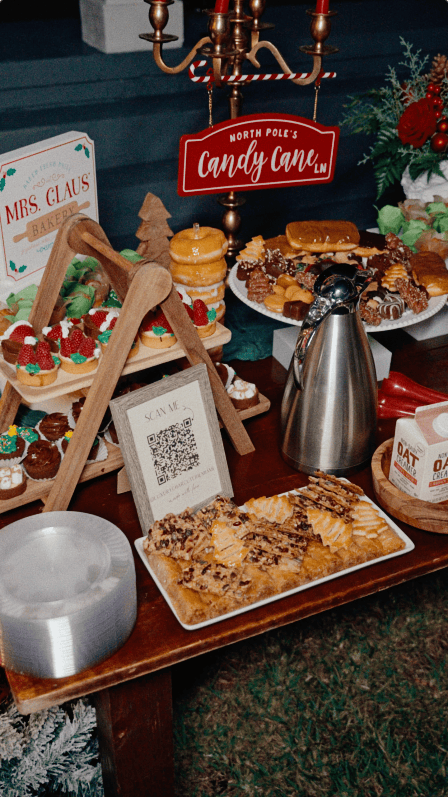 Candy Cane Lane dessert station with Christmas pastries, strawberry tarts, red signage, and gold candelabra.