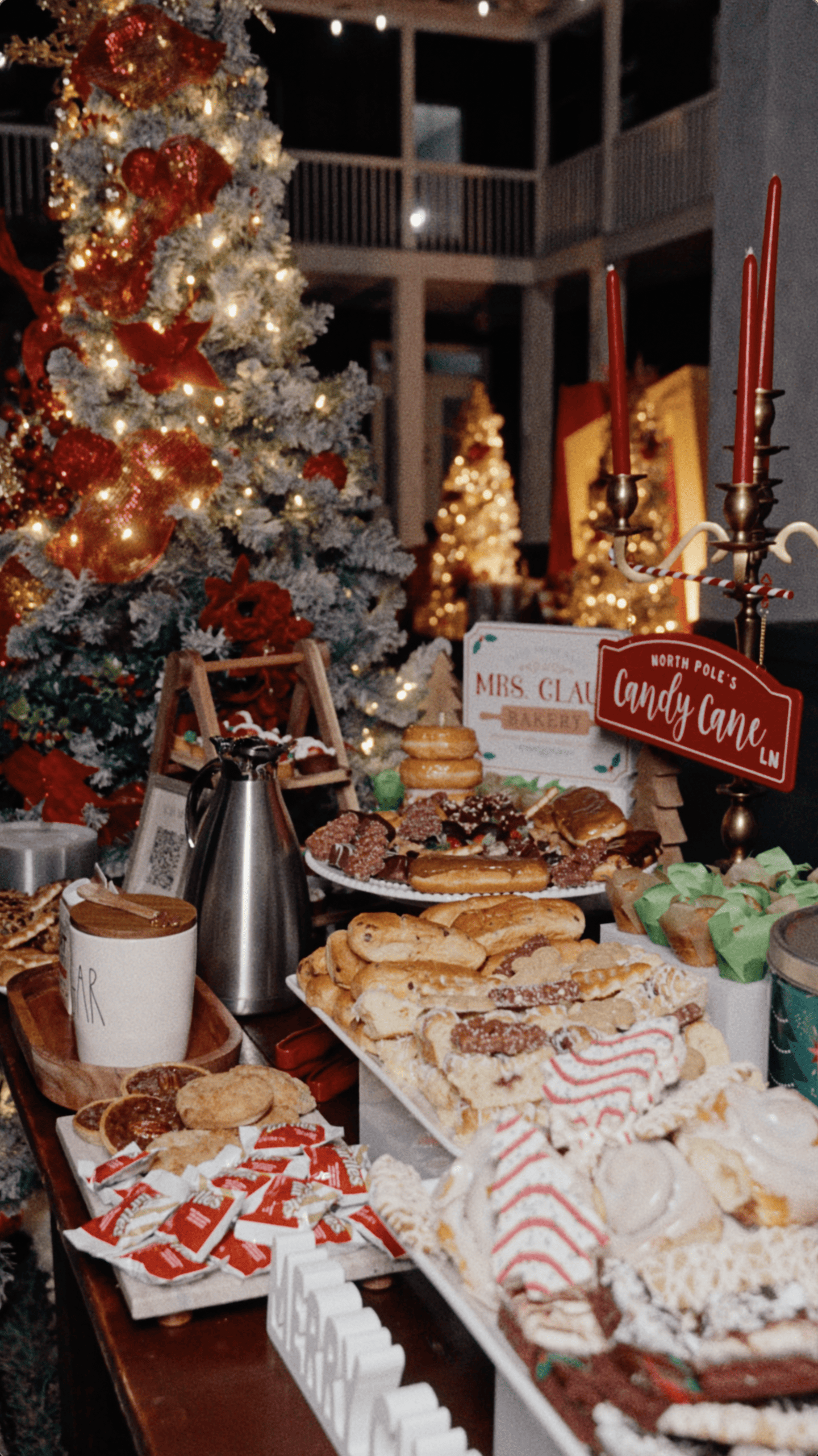 Christmas dessert buffet with holiday pastries, a decorated tree, red candles, and Candy Cane Lane decorations.