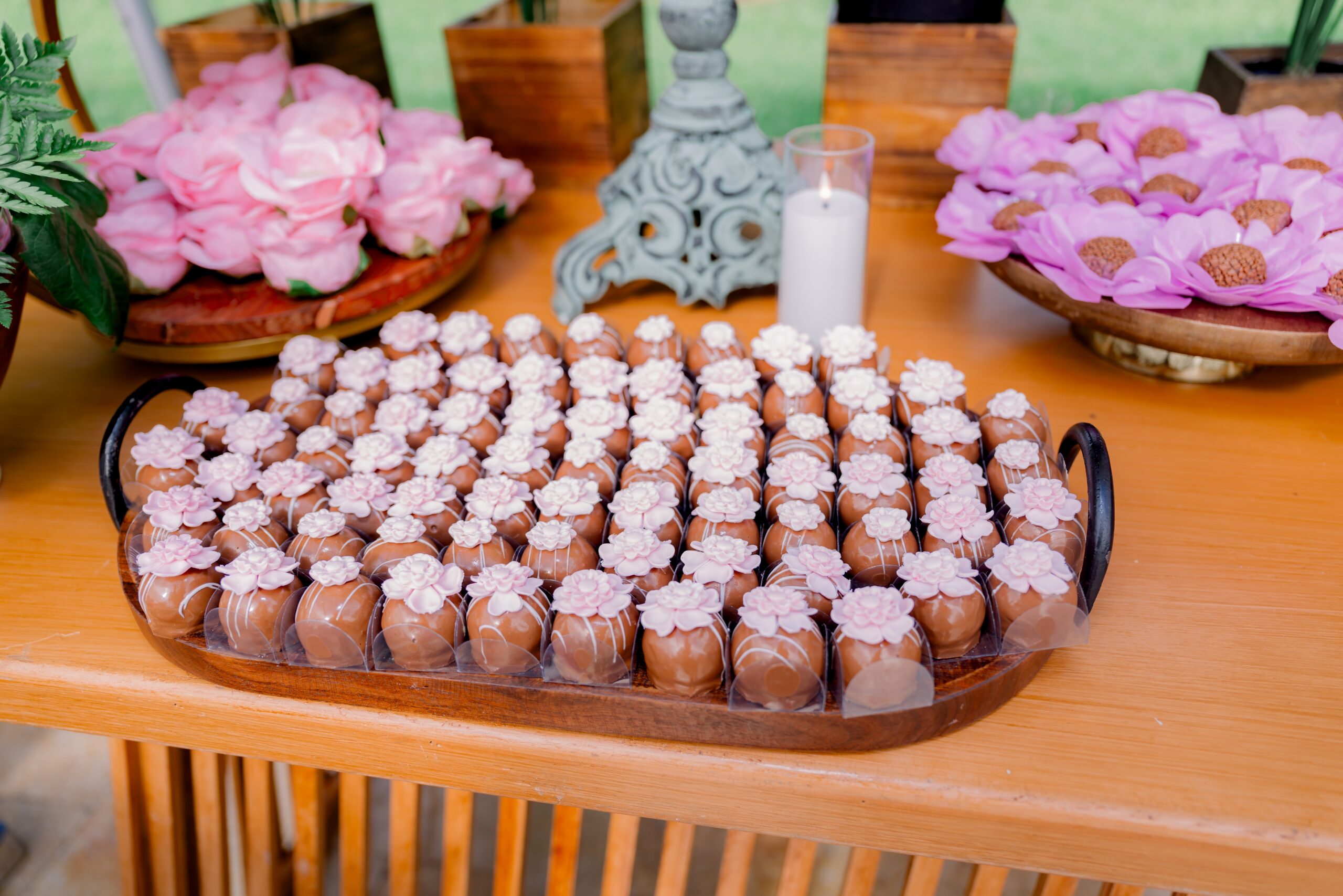 Elegant chocolate truffles with pink floral toppers at a stylish South Florida brunch celebration.