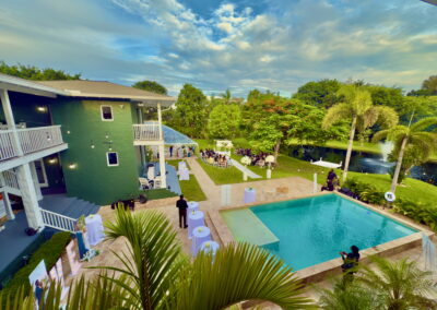 Elegant poolside view of Saint Patrick Palace with garden ceremony and lakefront fountain backdrop.