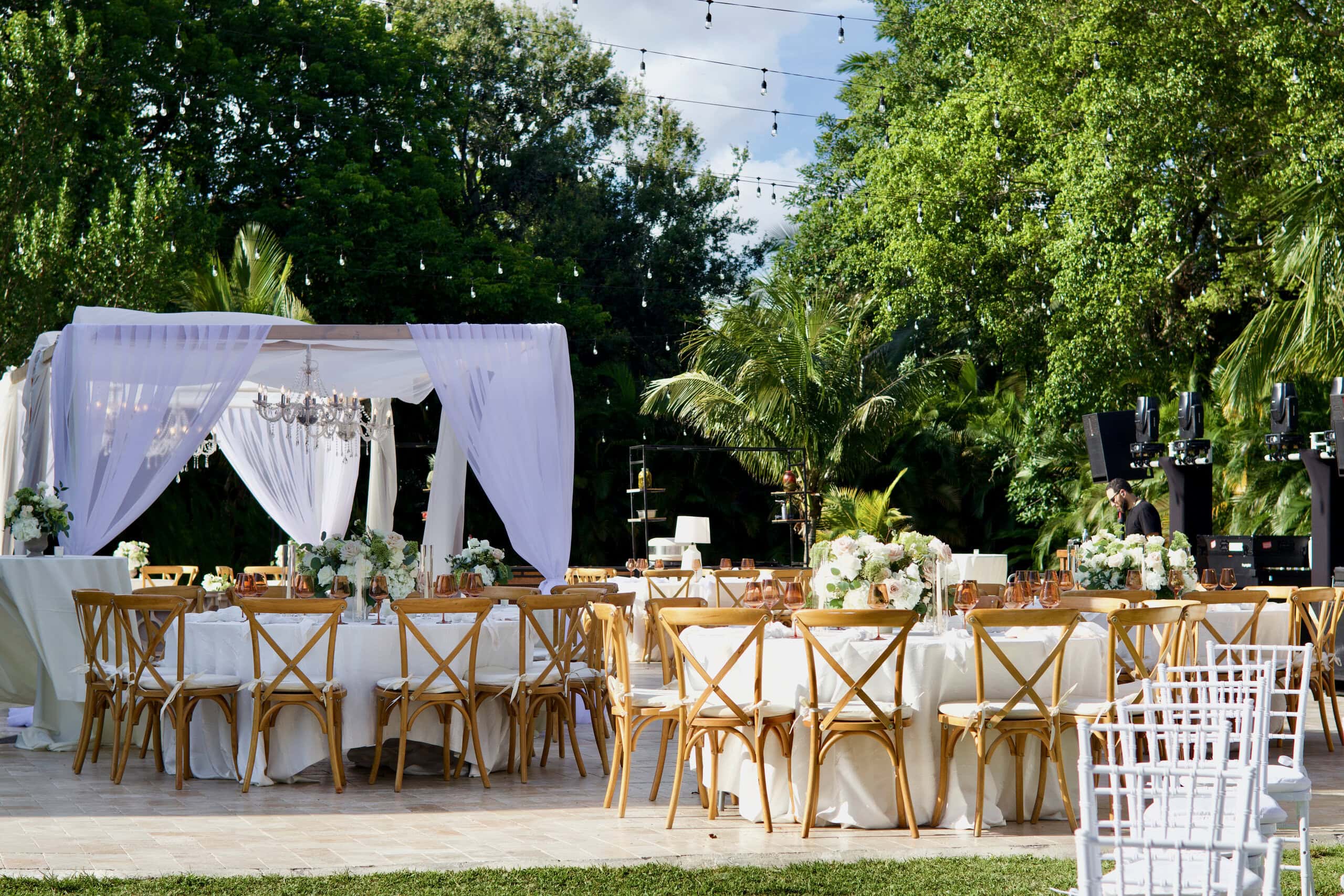 Elegant outdoor wedding reception with draping, chandeliers, and floral centerpieces at Saint Patrick Palace.