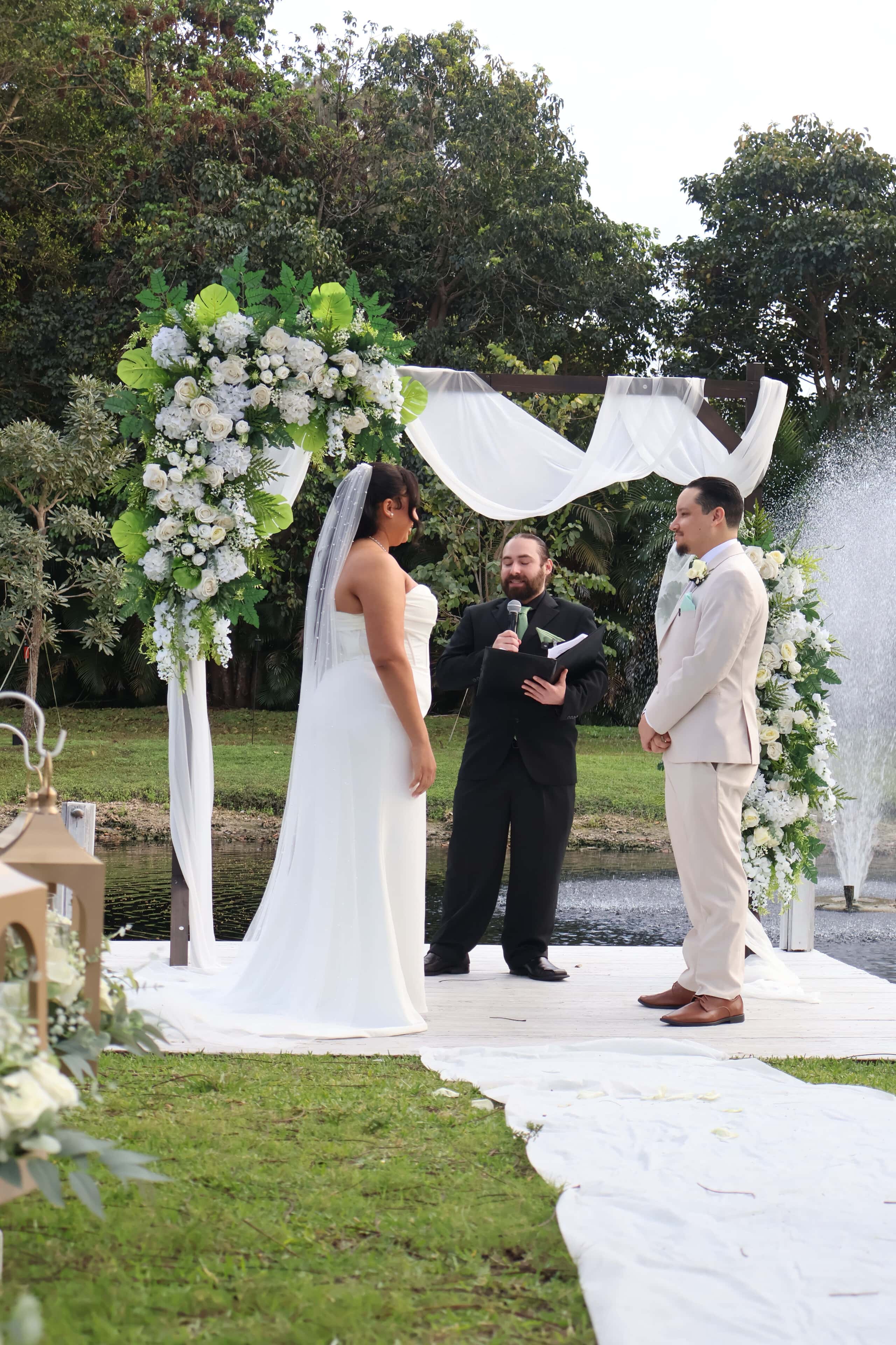 Bride and groom exchanging vows during a waterfront wedding ceremony at a Florida wedding venue.
