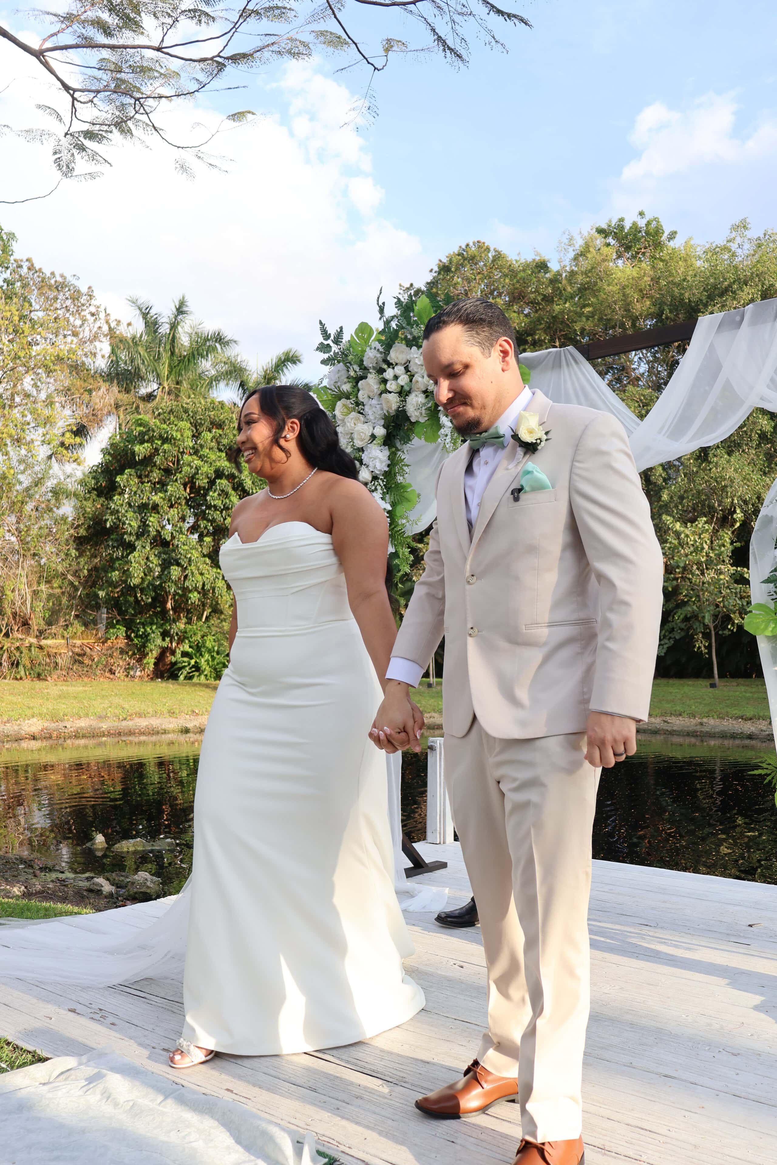 Newly married couple walking down the aisle after a waterfront wedding ceremony in Florida.