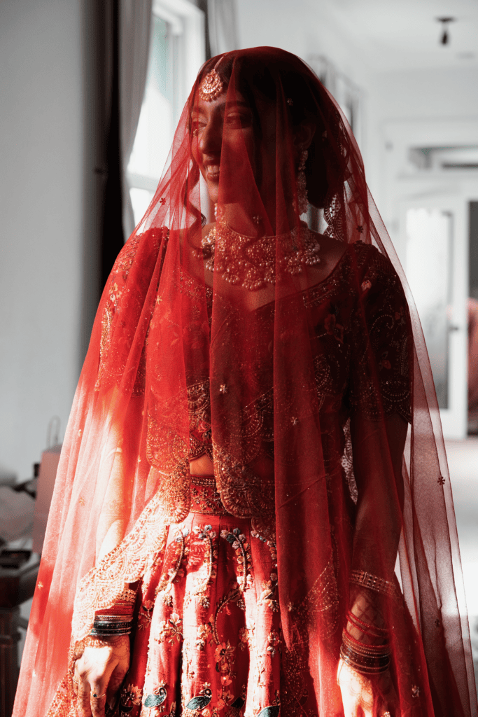 South Asian bride in a naturally lit bridal suite at a Florida wedding venue before her ceremony.