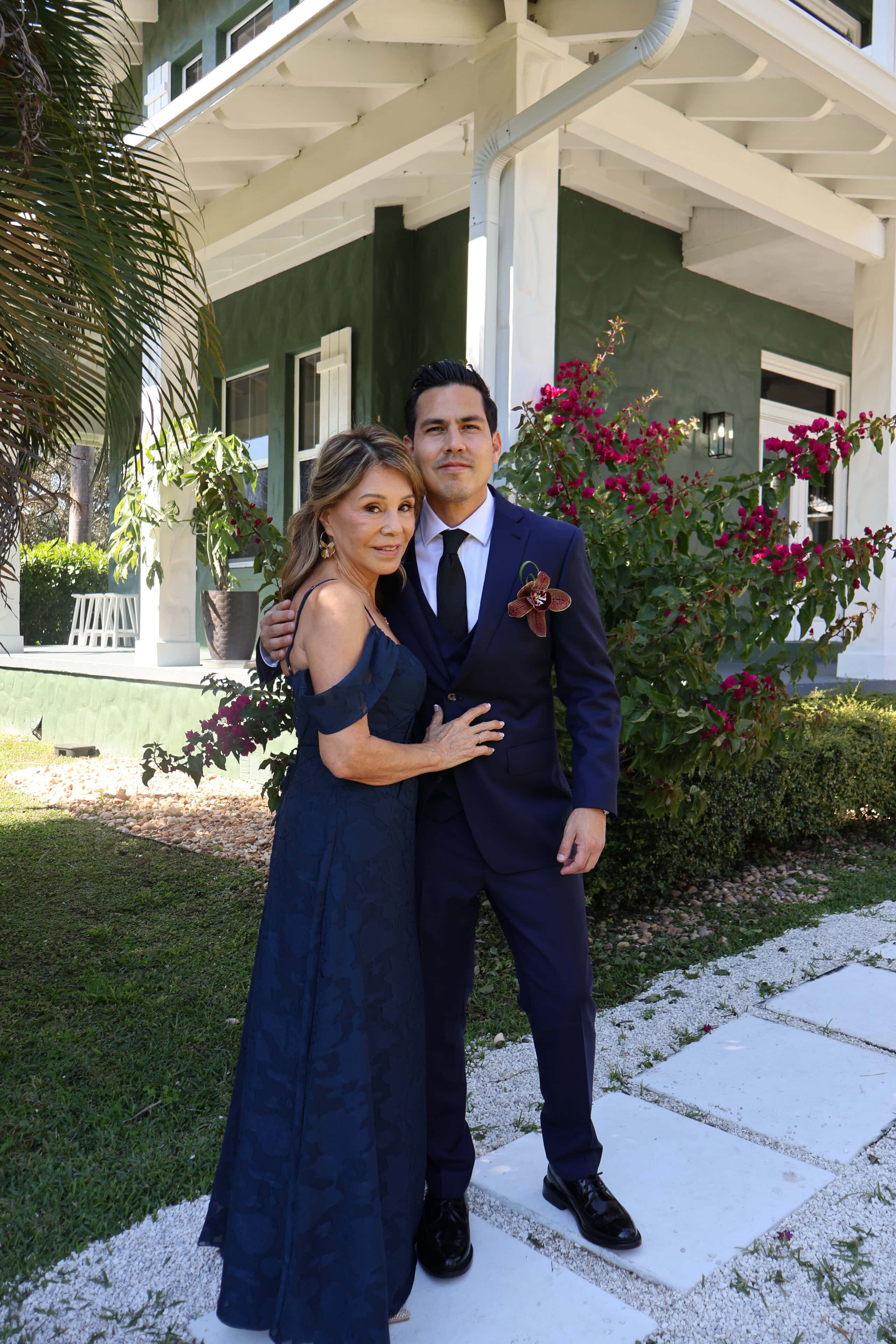 Groom and mother posing together at Saint Patrick Palace wedding venue in Davie Florida during real wedding