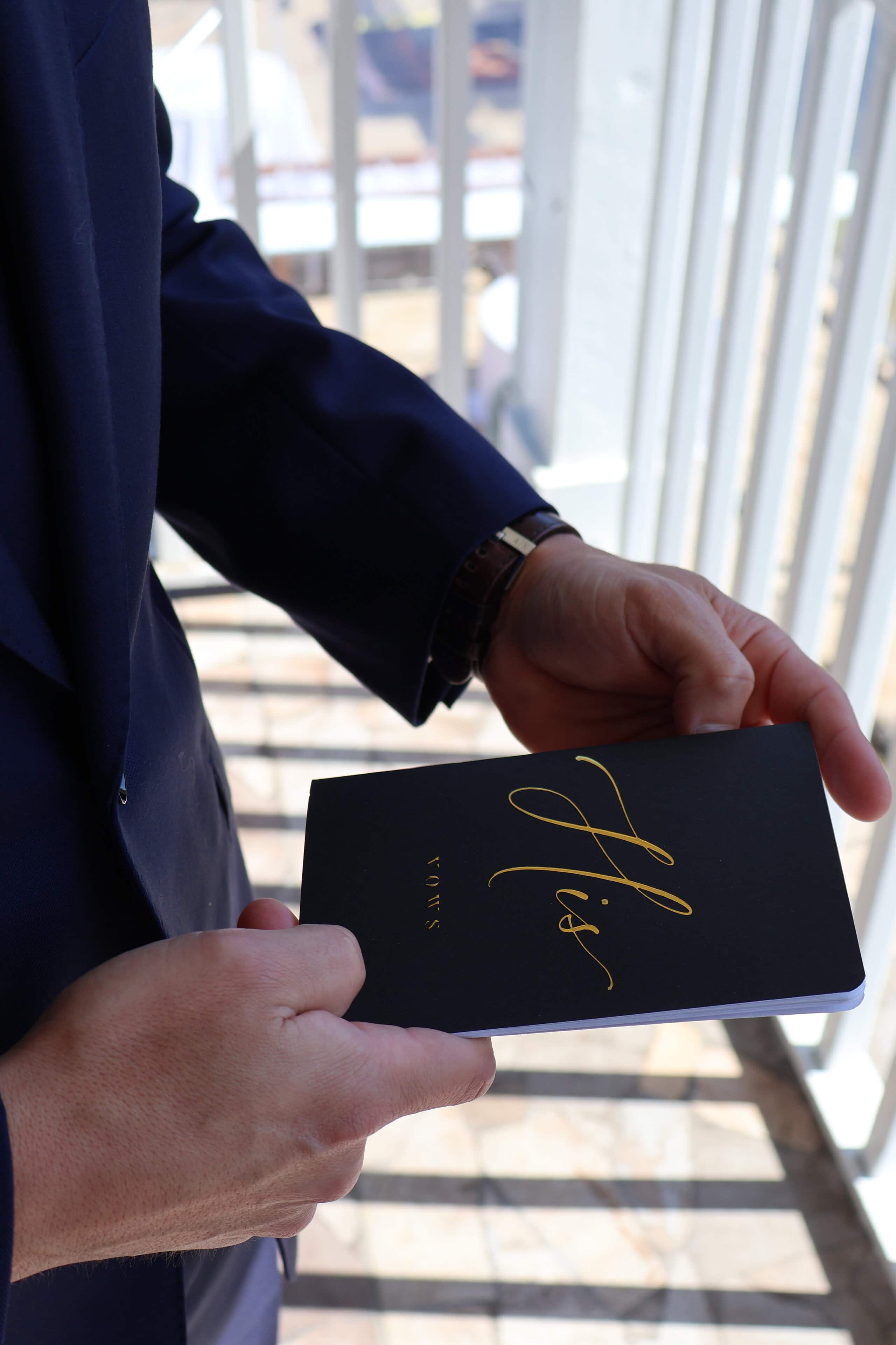 Groom holding vows booklet before ceremony at Saint Patrick Palace South Florida wedding venue