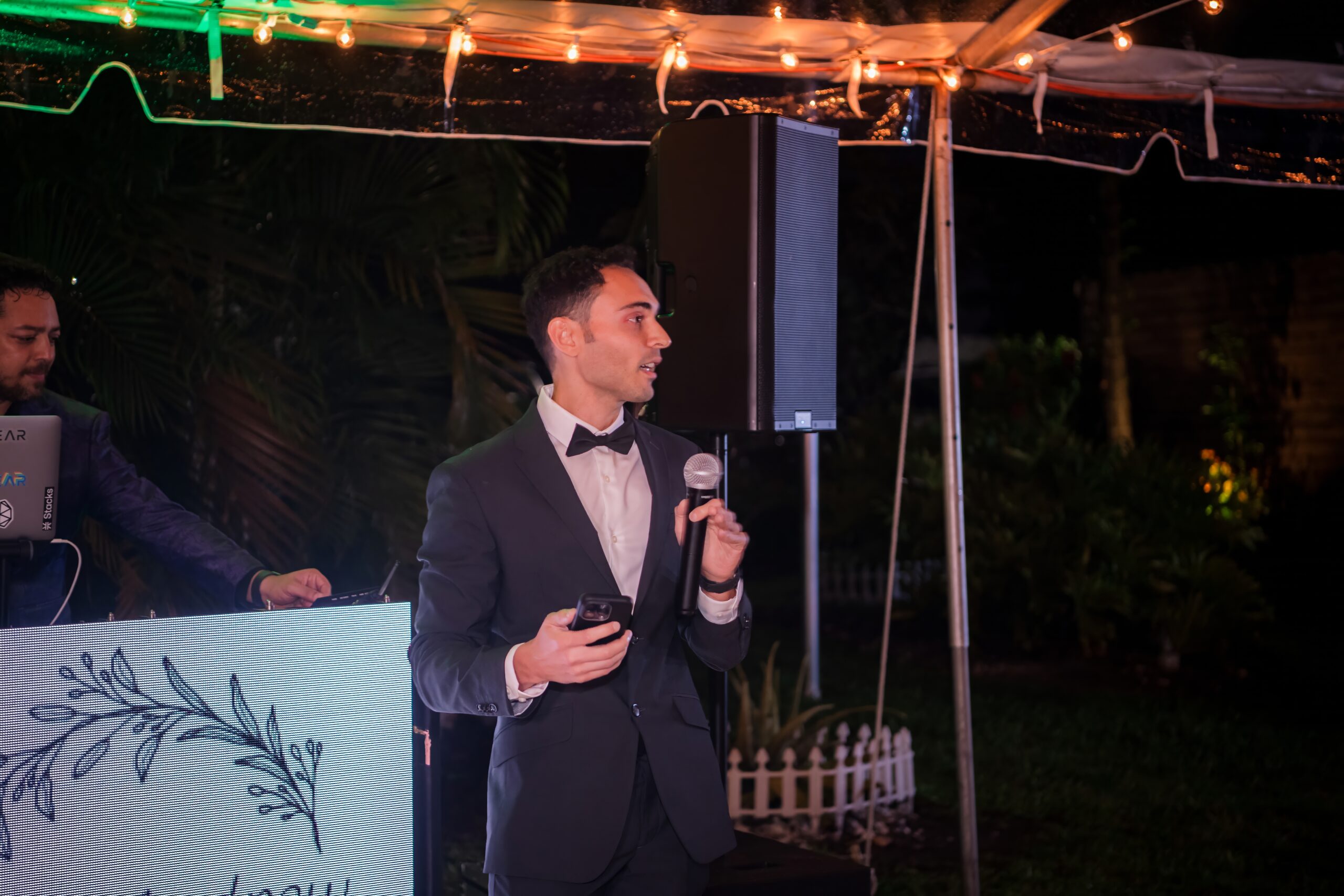 Man giving a heartfelt retirement speech under glowing lights at an elegant evening celebration.