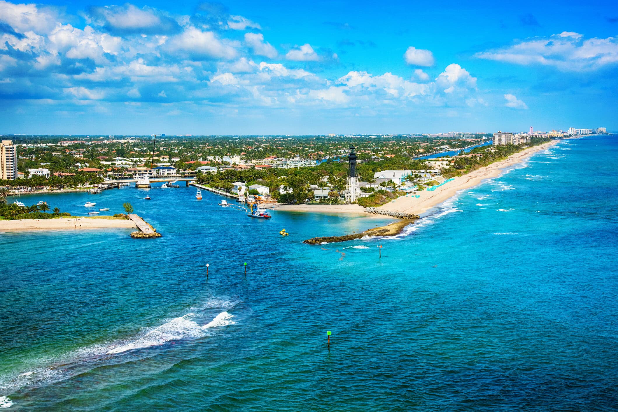 Aerial view of Hillsboro Inlet, Hillsboro Lighthouse, Atlantic coastline, and turquoise waters near Pompano Beach.