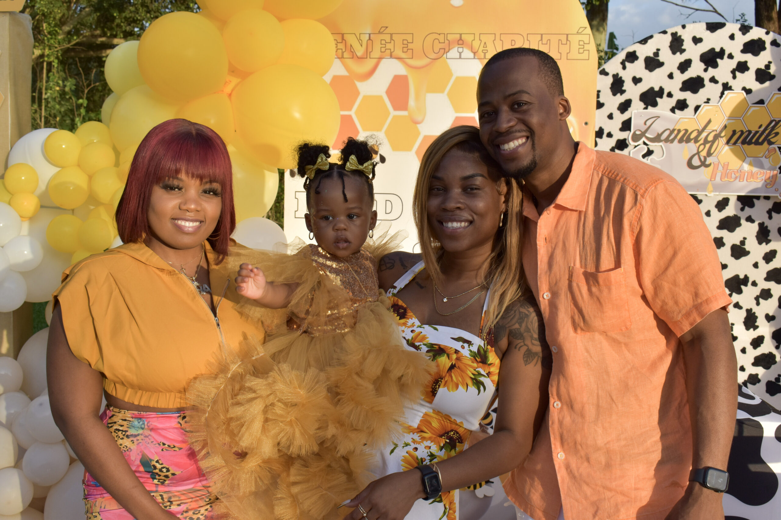 Family smiles during a honey-themed 1st birthday celebration at Saint Patrick Palace in South Florida.
