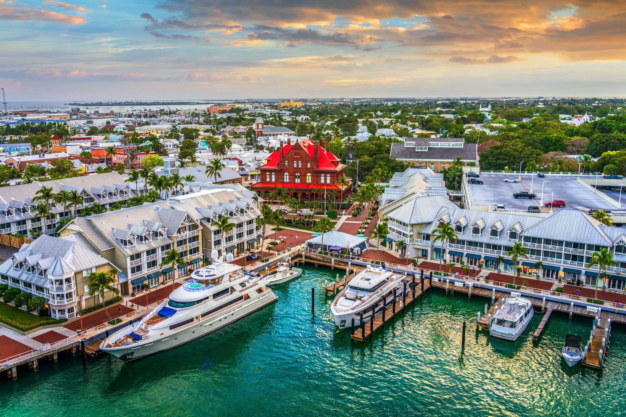 Aerial view of Key West with turquoise water, yachts, marina docks, historic architecture, and tropical island scenery.