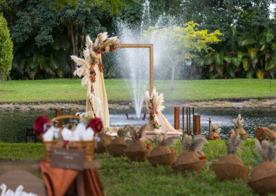Lakeside wedding ceremony arch with pampas grass and floral décor at a romantic outdoor celebration.