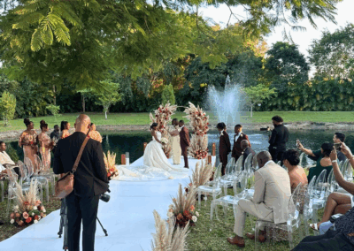Lakeside wedding ceremony at a private South Florida estate with pampas décor and elegant floral accents.